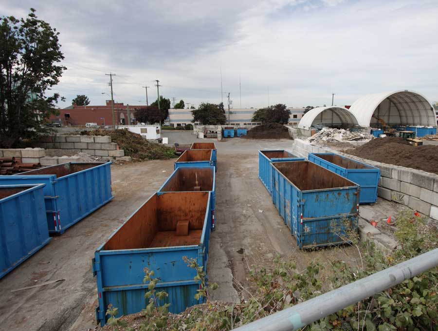 Abandoned site with blue dumpsters.