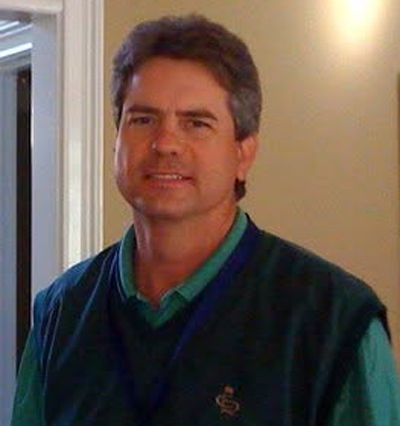 Clay Bednarz Man in green sweater vest smiling - Clay Bednarz