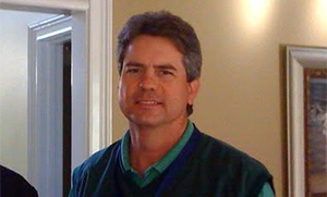 Man in green sweater vest smiling - Clay Bednarz